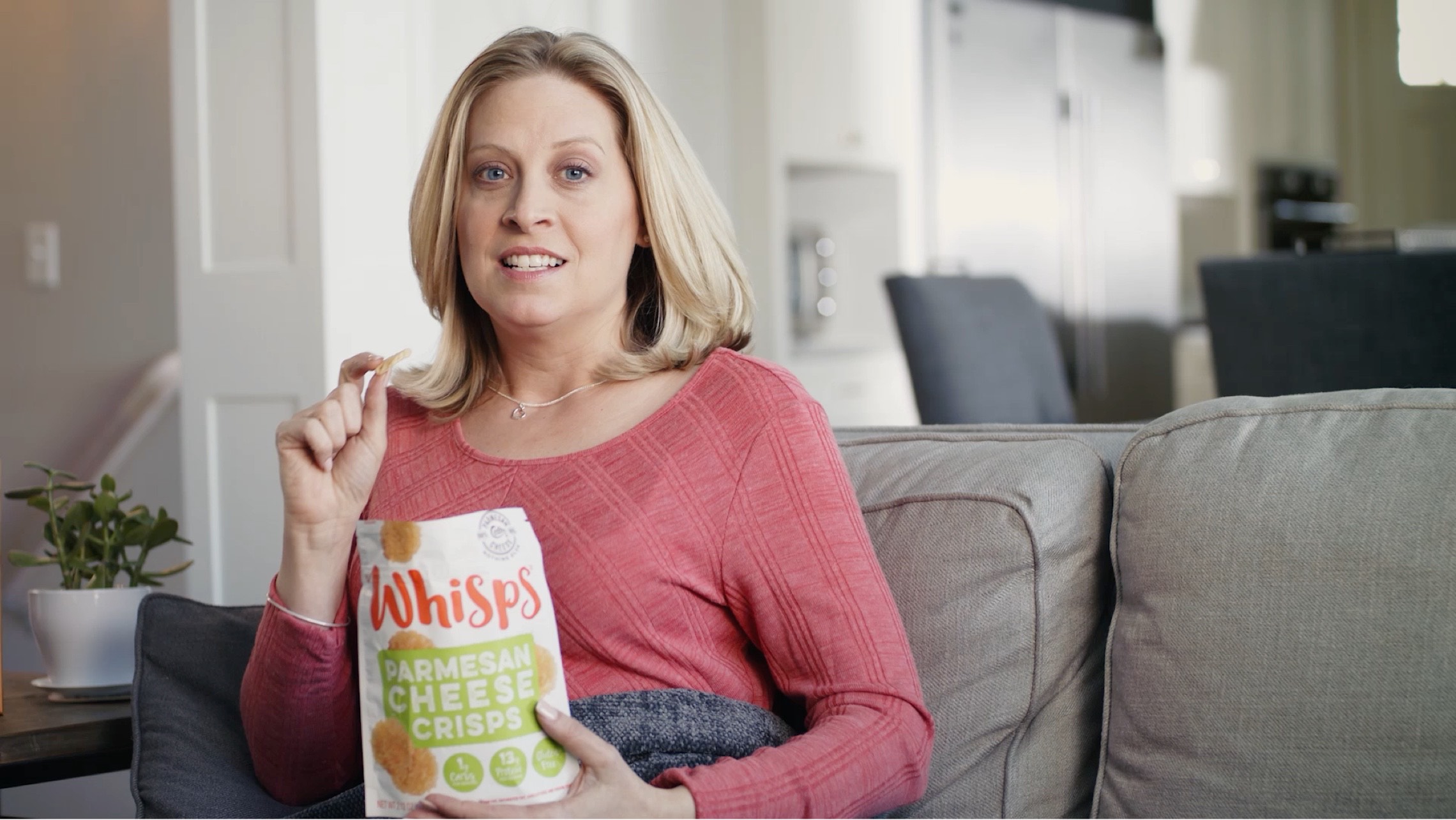 Woman sitting with a bag of Whisps. Click to watch the video.