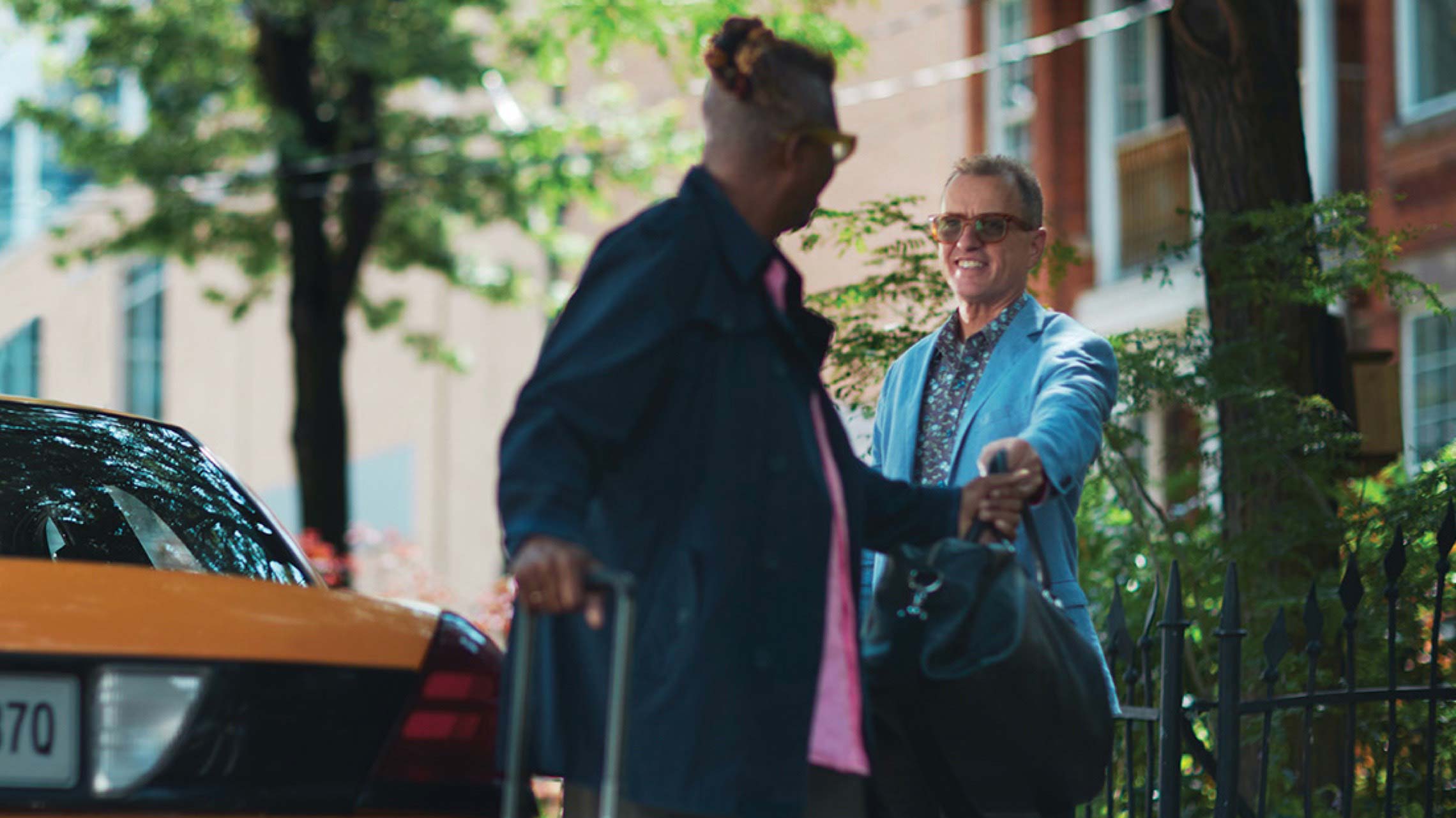 Photograph of two people near a taxi.